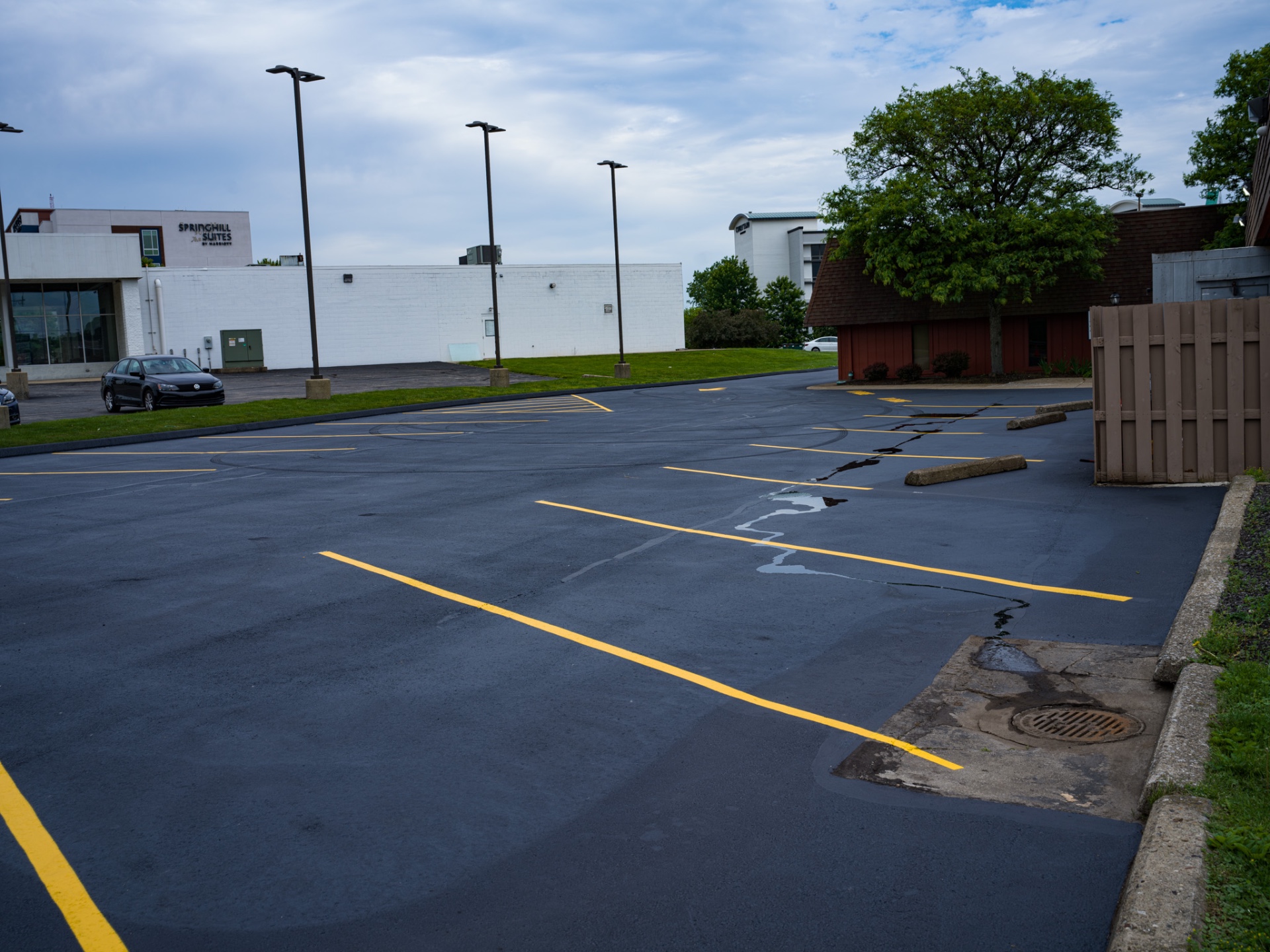 Freshly sealcoated commercial parking lot with crisp yellow striping in Ohio