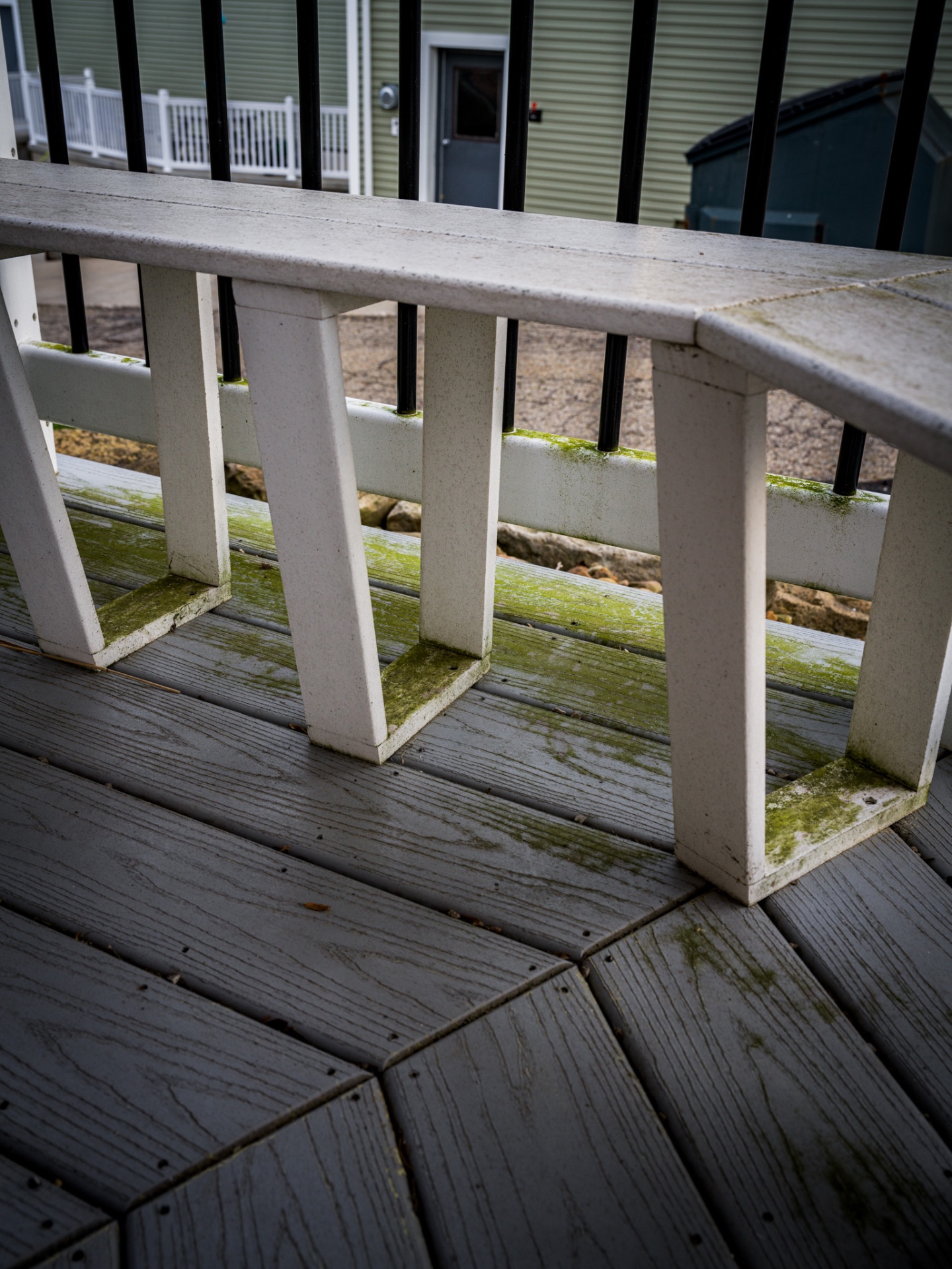 Mossy composite deck with algae buildup before pressure washing